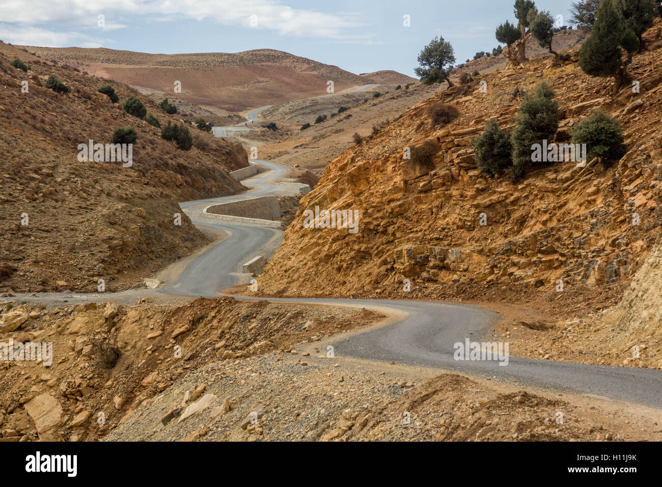 Winding Road nel cuore dell'Alto Atlante che conduce attraverso le Montagne Alto Atlante Foto Stock