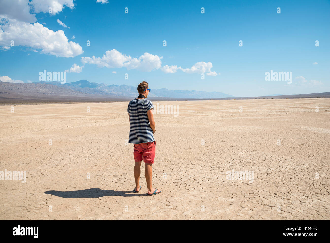 Giovane uomo cercando attraverso vasto paesaggio, Valle della Morte, il Parco Nazionale della Valle della Morte, CALIFORNIA, STATI UNITI D'AMERICA Foto Stock