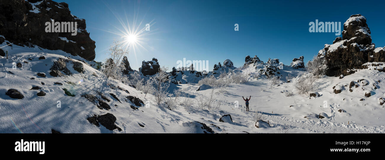 Donna sul sentiero nel paesaggio innevato, sole, campo di lava coperto di neve, Krafla sistema vulcanico, Dimmuborgir Parco Nazionale Foto Stock
