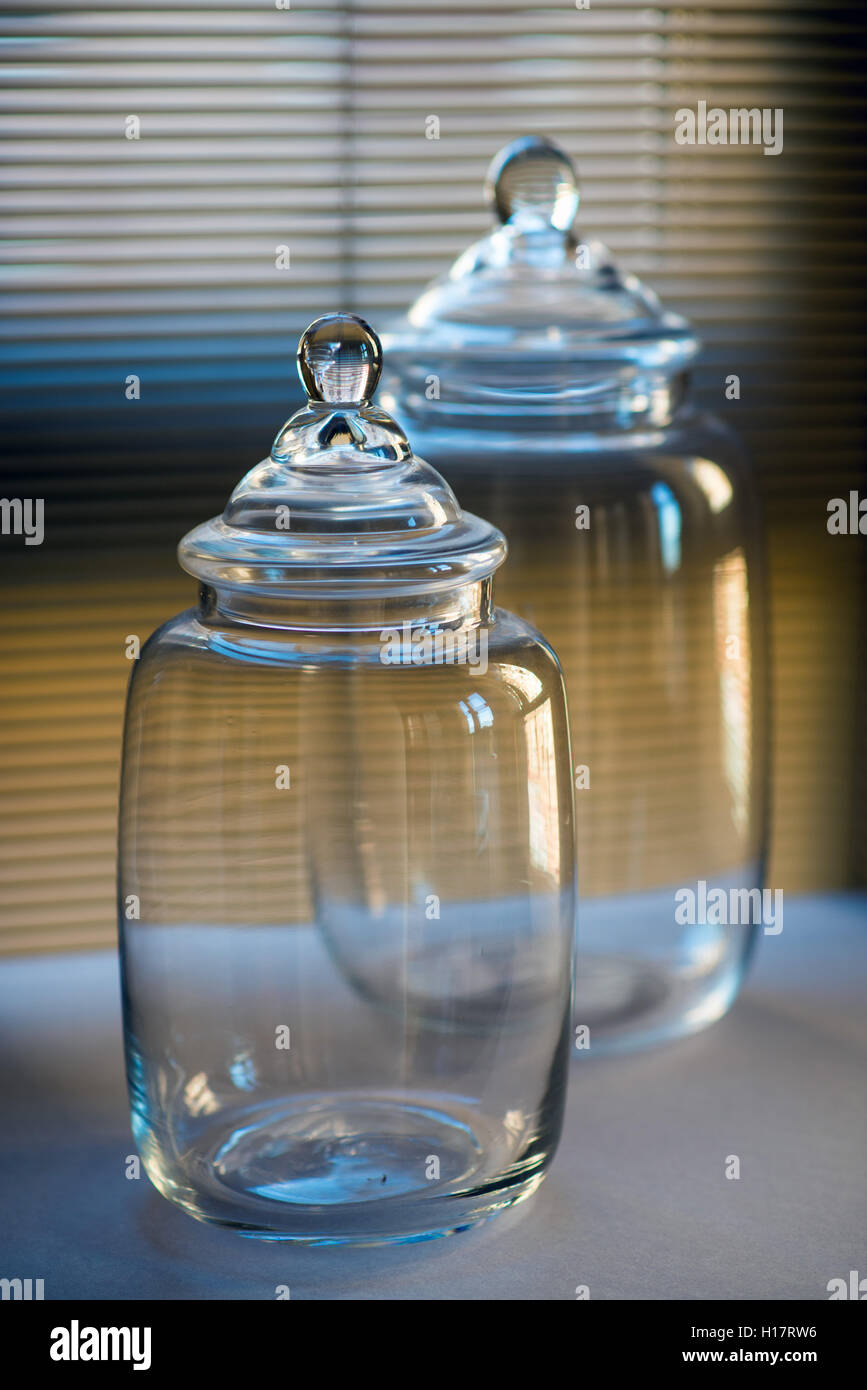 Vasi di vetro su uno sfondo di tenda a veneziana Foto Stock