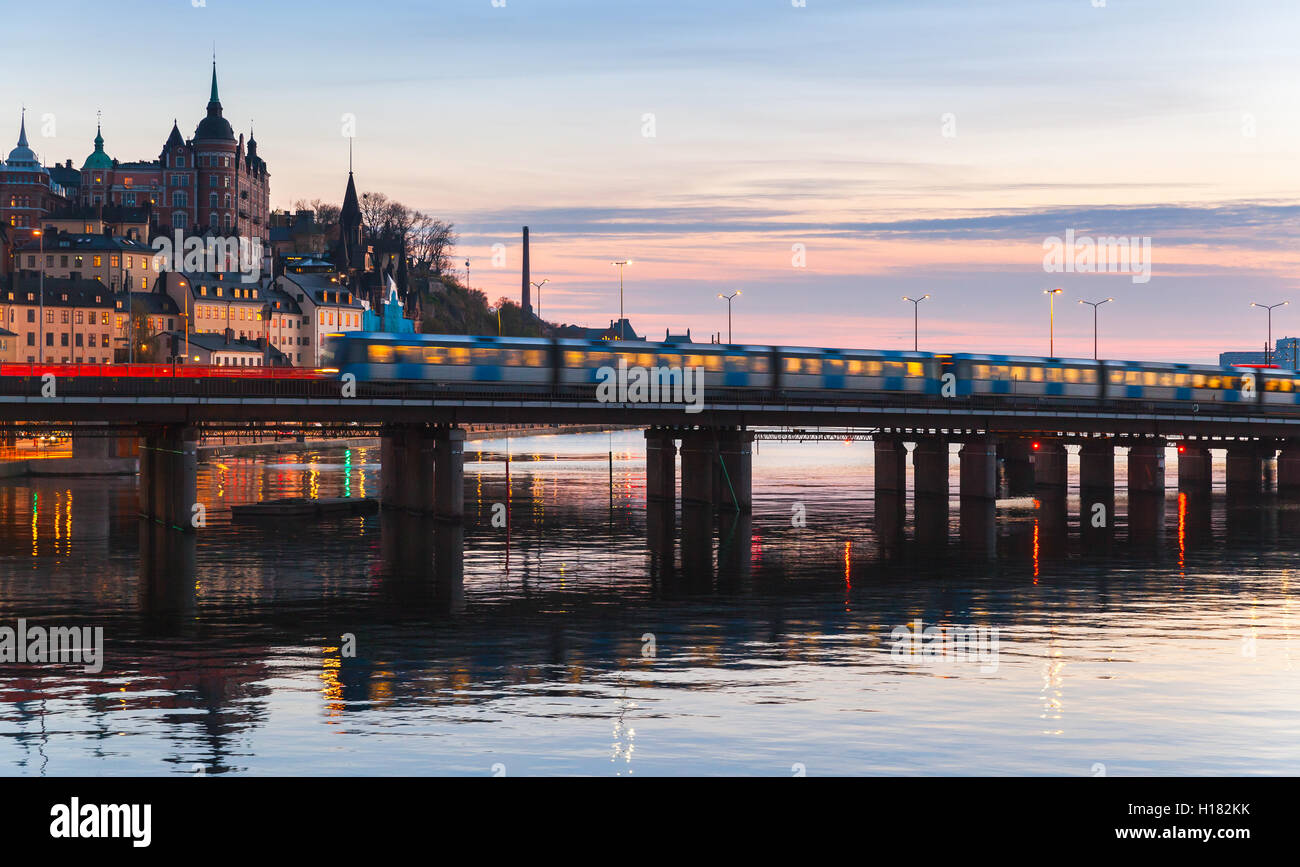 Sera cityscape con Metro treno sul ponte di Gamla Stan, Stoccolma, Svezia Foto Stock