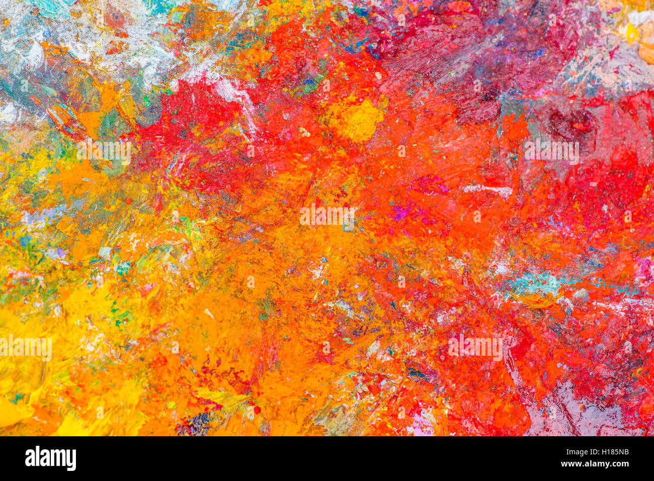 Colorato modello astratto fatto di un essiccata vernice di olio su una superficie di un artista della tavolozza. Luminose e colori vivaci. Rosso, viola Foto Stock