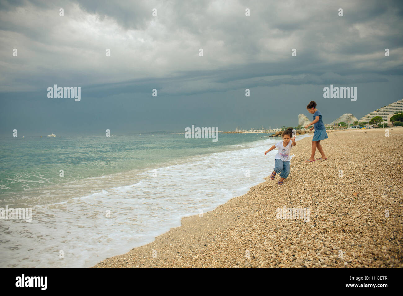 Foto di stock di 2 sorelle che stanno giocando sulla spiaggia, Villeneuve Loubet, Francia Foto Stock