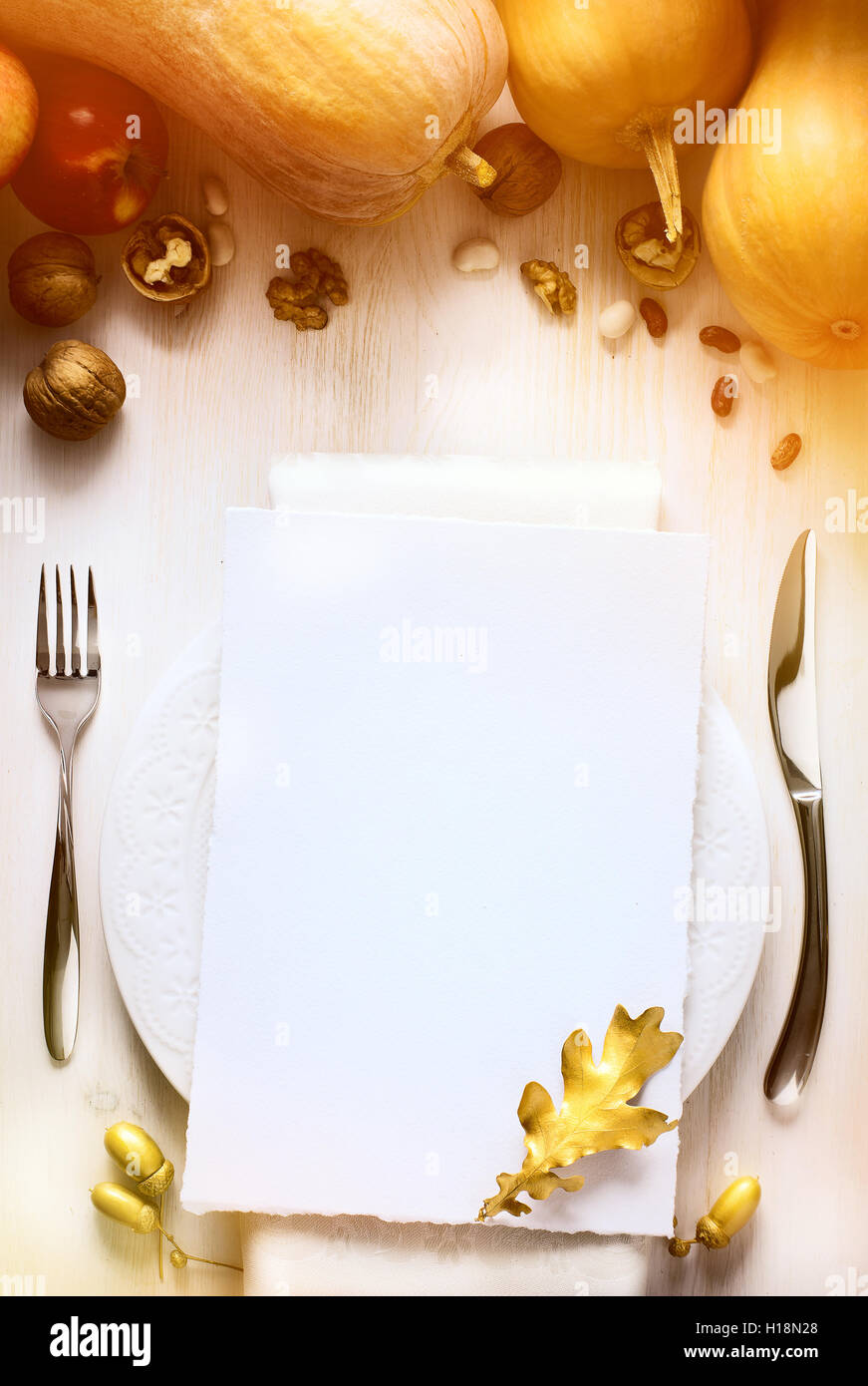 Nota di ringraziamento con sfondo autunno zucca sul tavolo da pranzo Foto Stock