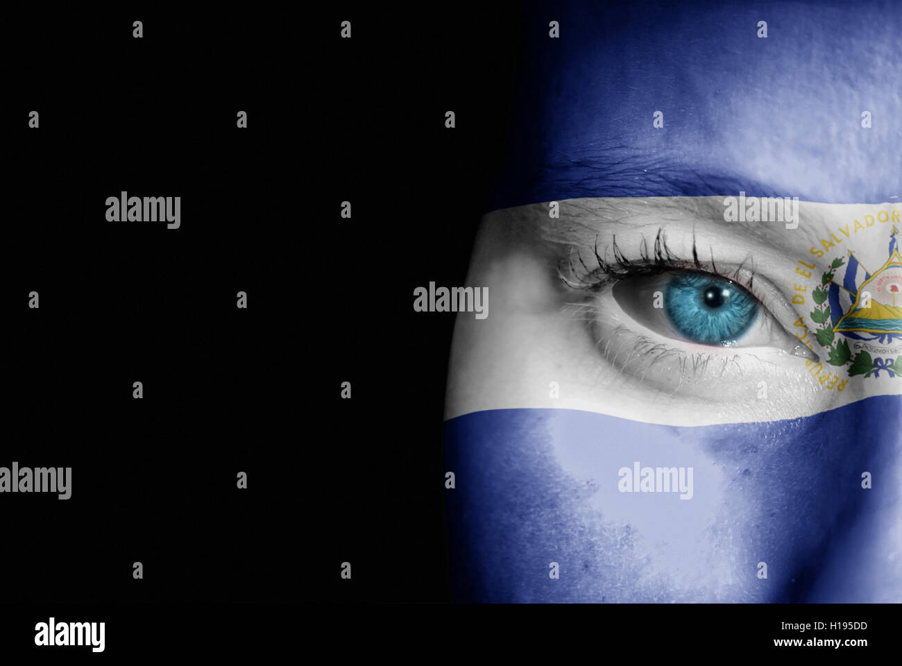 Una giovane donna con la bandiera di El Salvador dipinta sulla sua faccia sul suo modo ad un evento sportivo per mostrare il suo supporto. Foto Stock