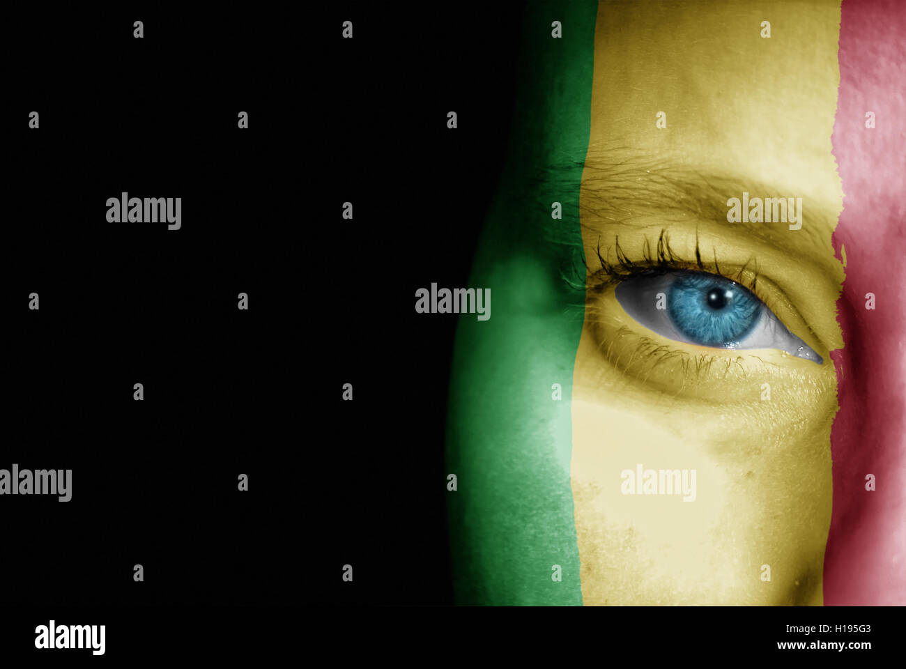 Una giovane donna con la bandiera del Mali dipinta sulla sua faccia sul suo modo ad un evento sportivo per mostrare il suo supporto. Foto Stock