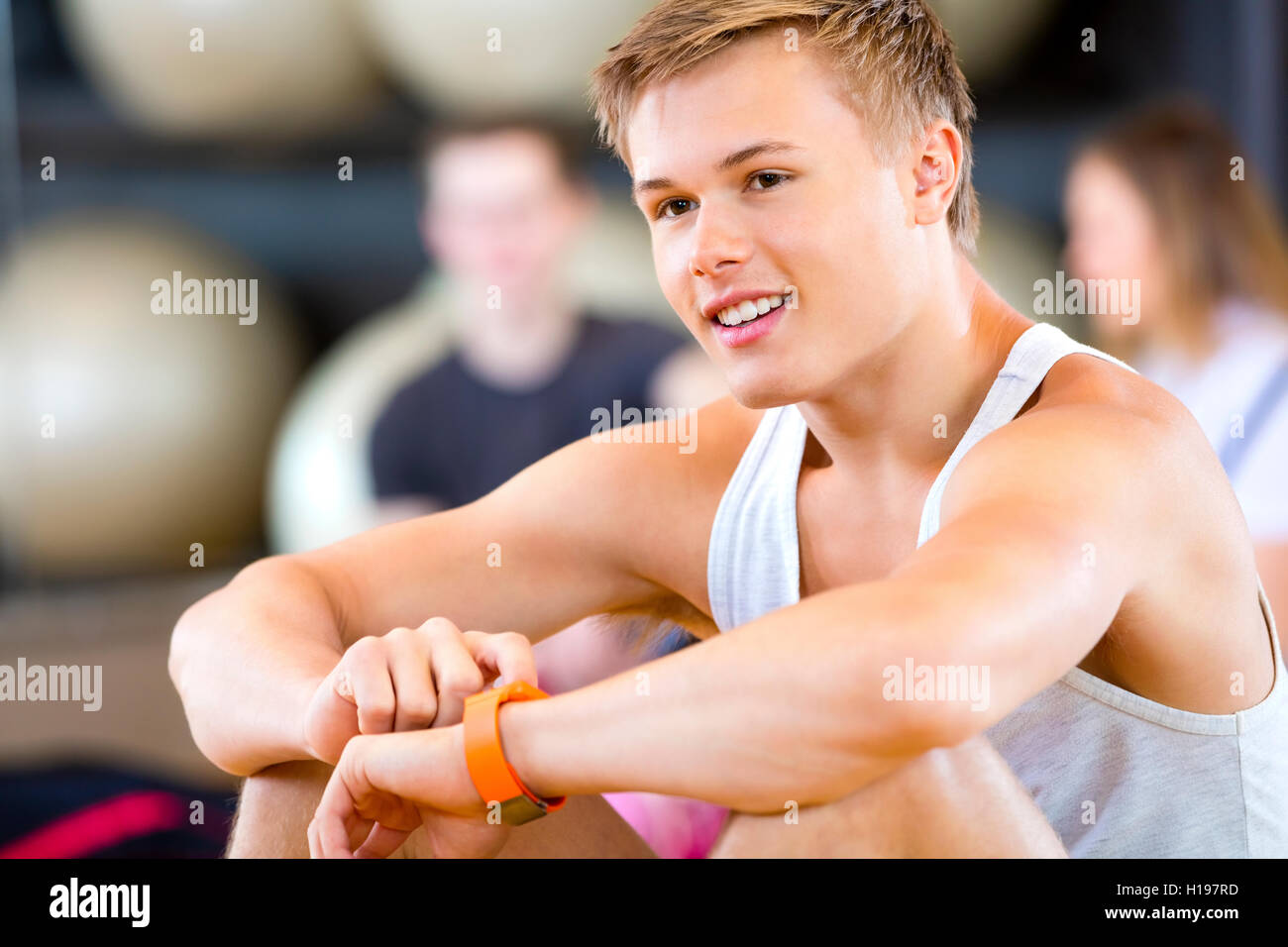 Uomo che utilizza Smart a guardare mentre guarda lontano in palestra Foto Stock