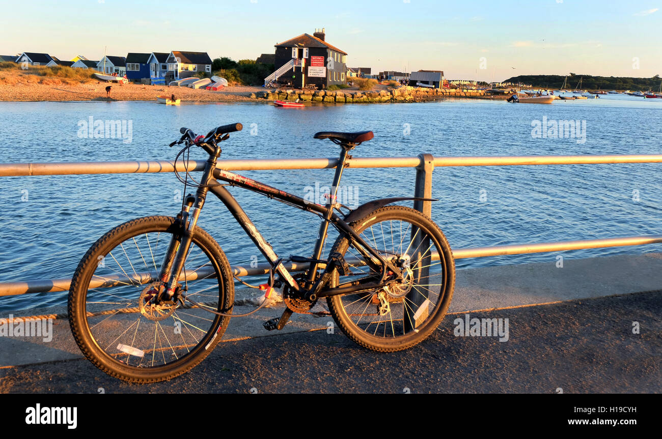Bike concatenati per ringhiere, guardando fuori a sandbank Mudeford, Dorset, Regno Unito. Foto Stock