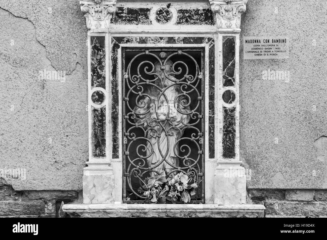 Un cattolico edicola votiva sulla parete del San Giacomo da l'Orio chiesa in Venezia, in bianco e nero. Foto Stock
