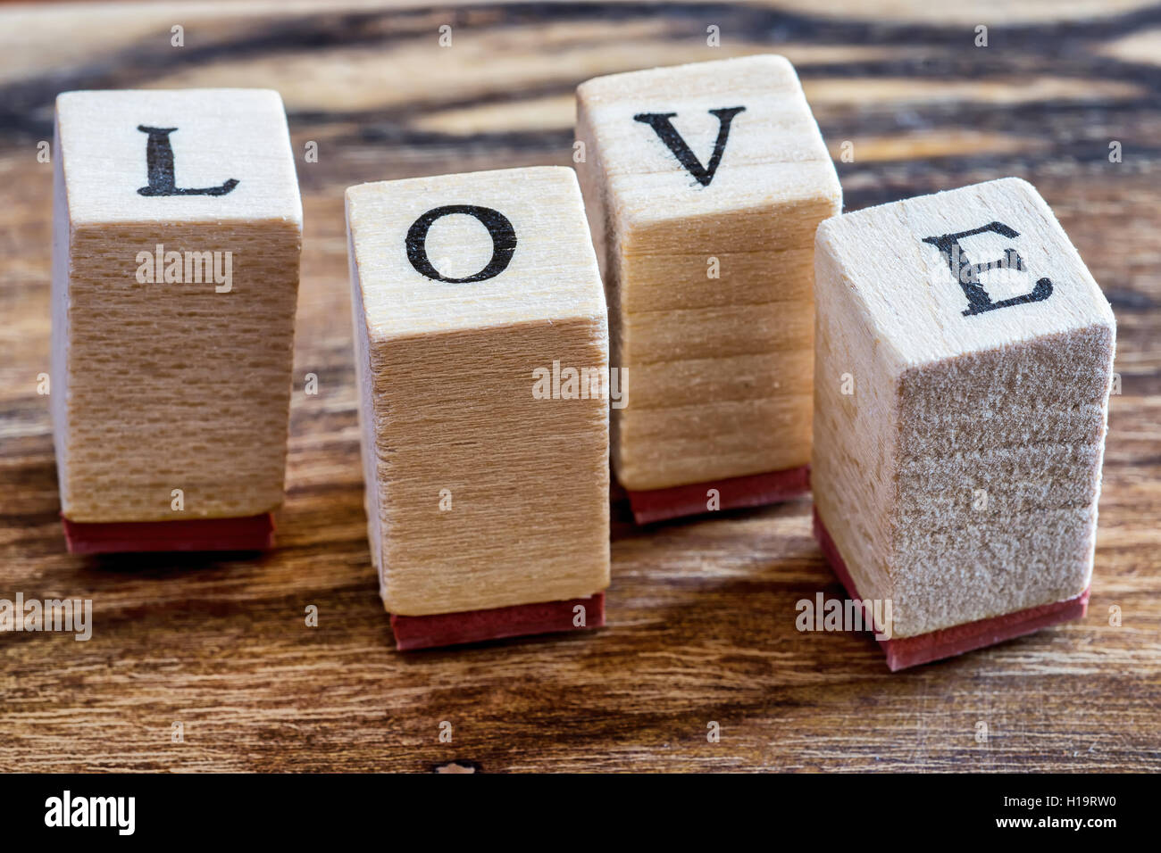 Amore felice il giorno di San Valentino del concetto. Amore timbro su Vintage Woden sfondo. Amore parola scritta in blocchetti di legno. Foto Stock