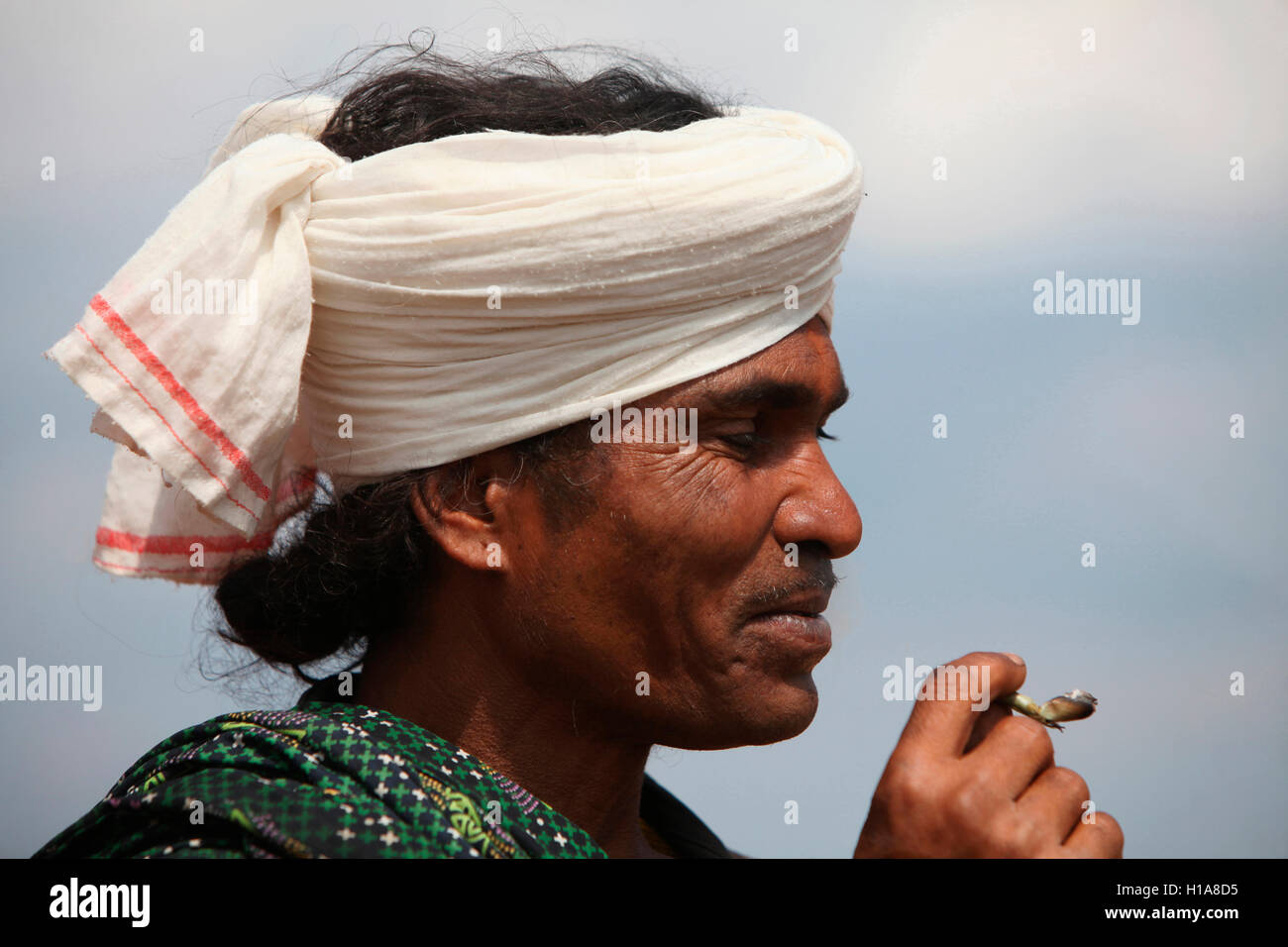 Uomo tribale che fuma un bidi, tribù di Muria, villaggio di Benur, Chattisgarh, India. Facce rurali dell'India Foto Stock
