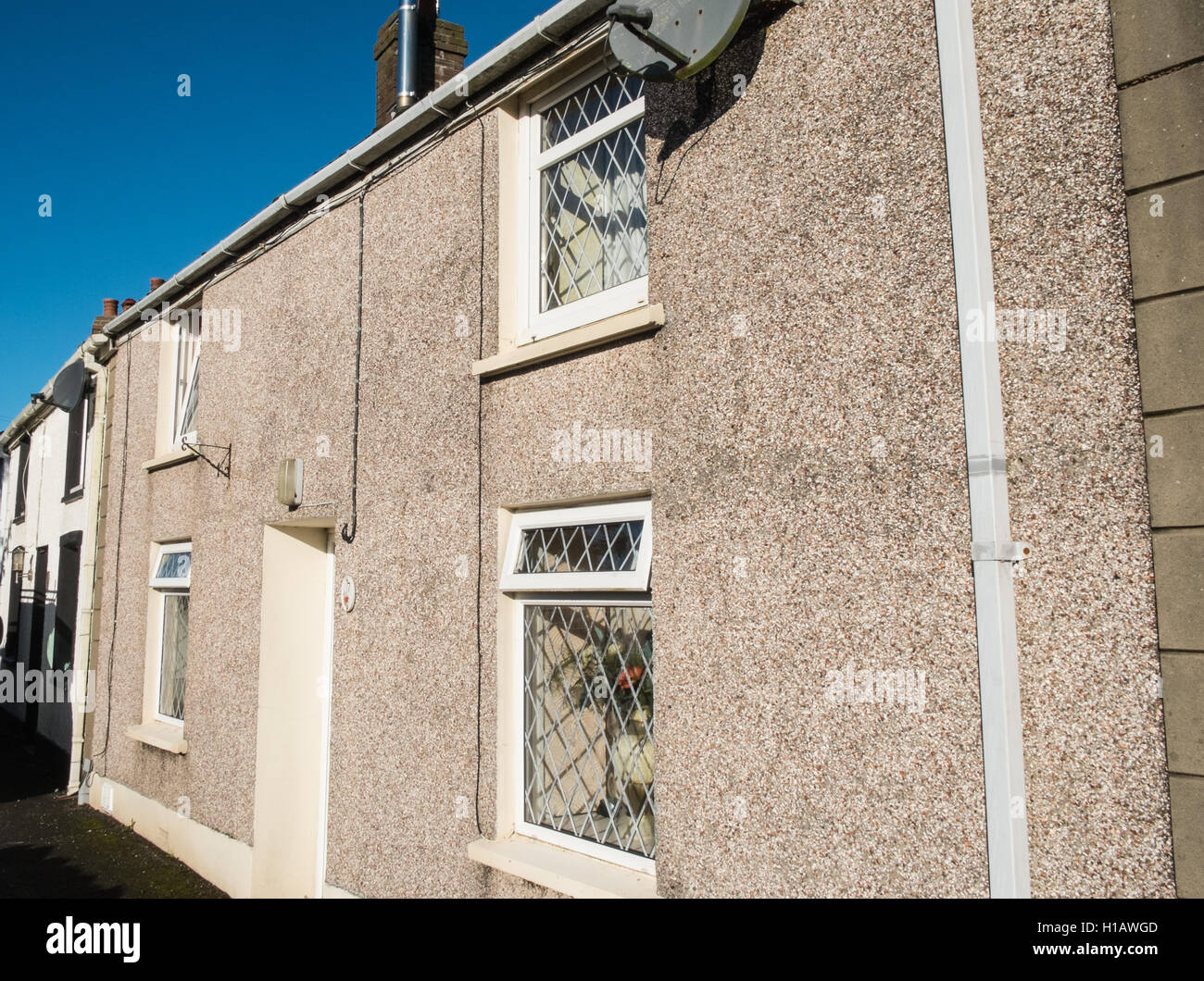 A tratti di ghiaia pareti di case a schiera,case vacanze nel centro del villaggio sulla collina di Llansaint,vicino Kidwelly,Carmarthenshire,Galles. Foto Stock