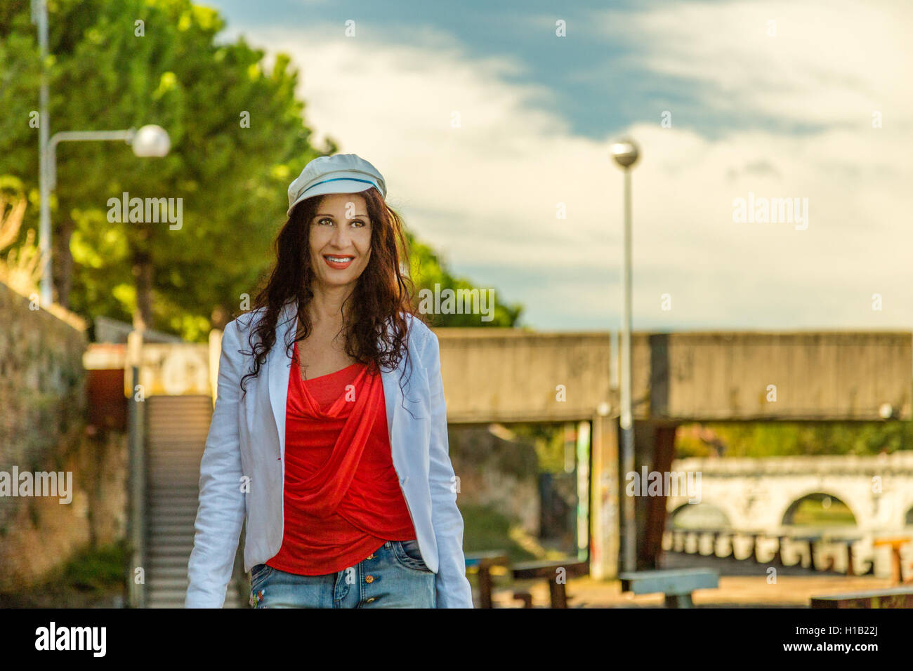 Rimini, Italia, donna consultando la mappa turistica con antico ponte romano in background Foto Stock
