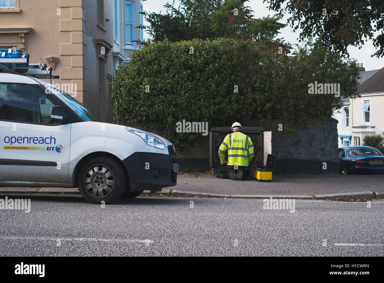 Un BT Openreach ingegnere alla apparecchiatura stradale mobile a banda larga di installazione Foto Stock