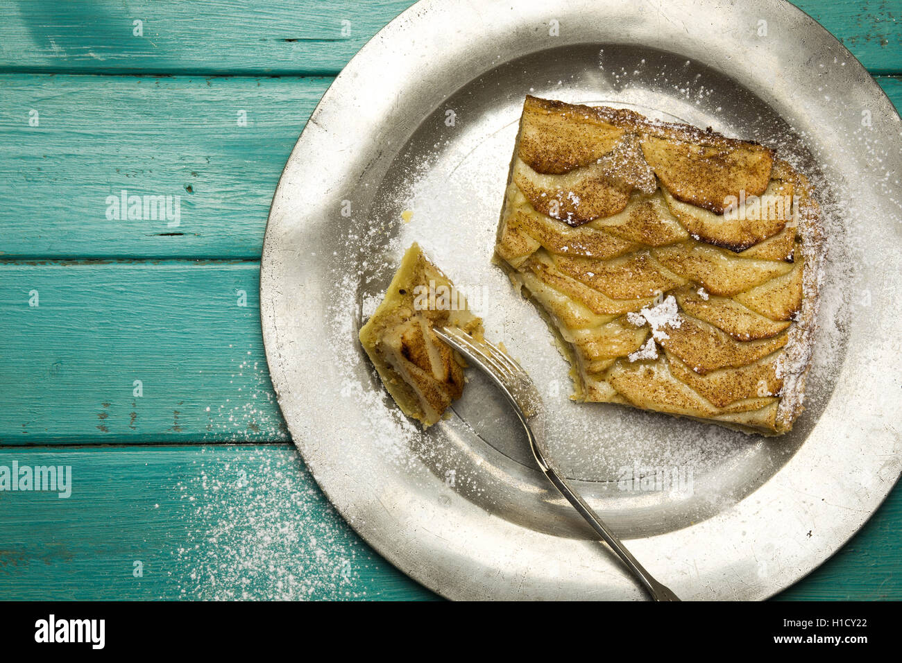 Mela cannella tart fetta con nocciola frangipane sulla piastra di stagno e sfondo turchese Foto Stock