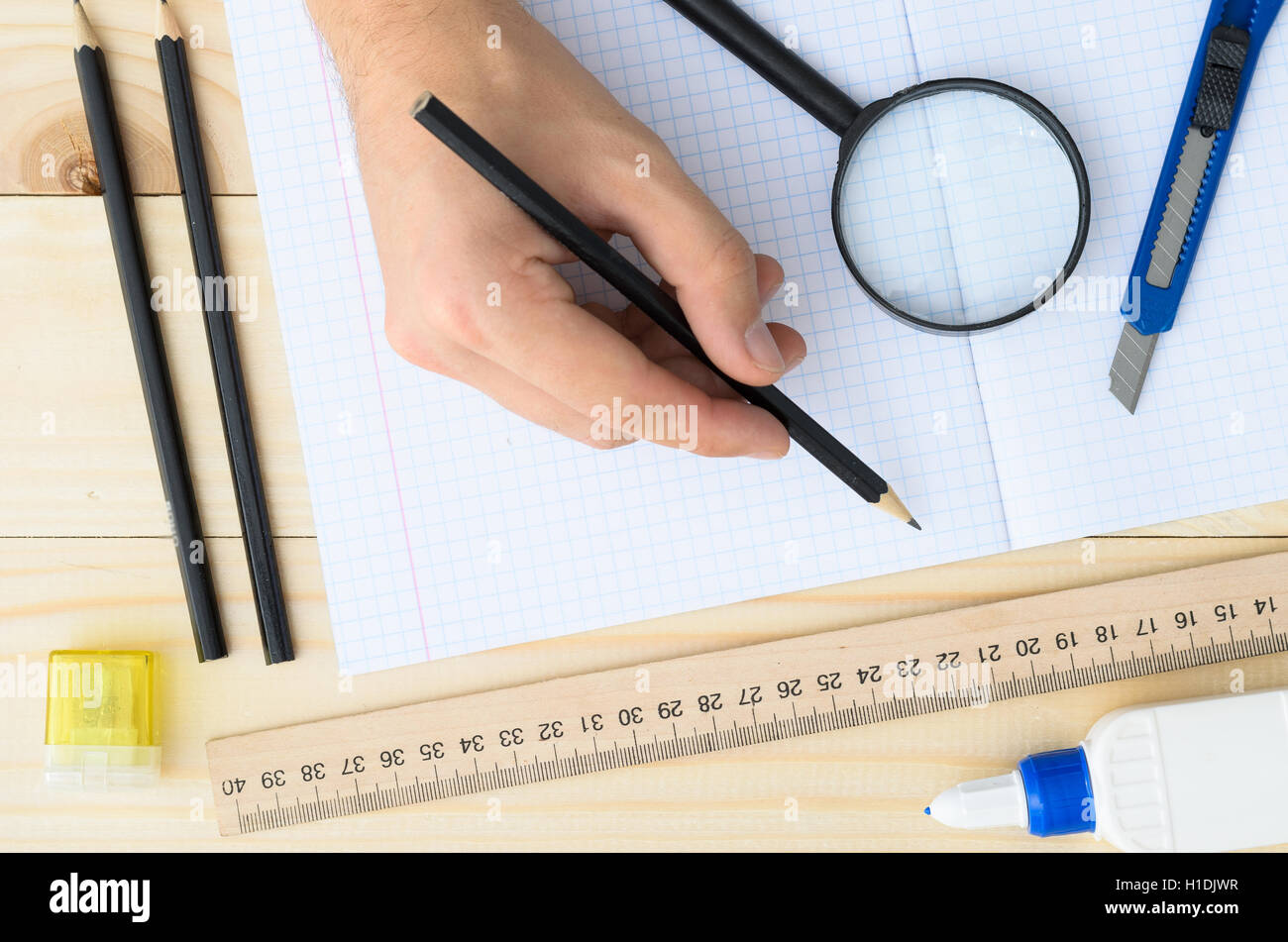 Disegnatore workplace dotato di righello, penna, cucitrice, forbici, lente di ingrandimento. Foto Stock