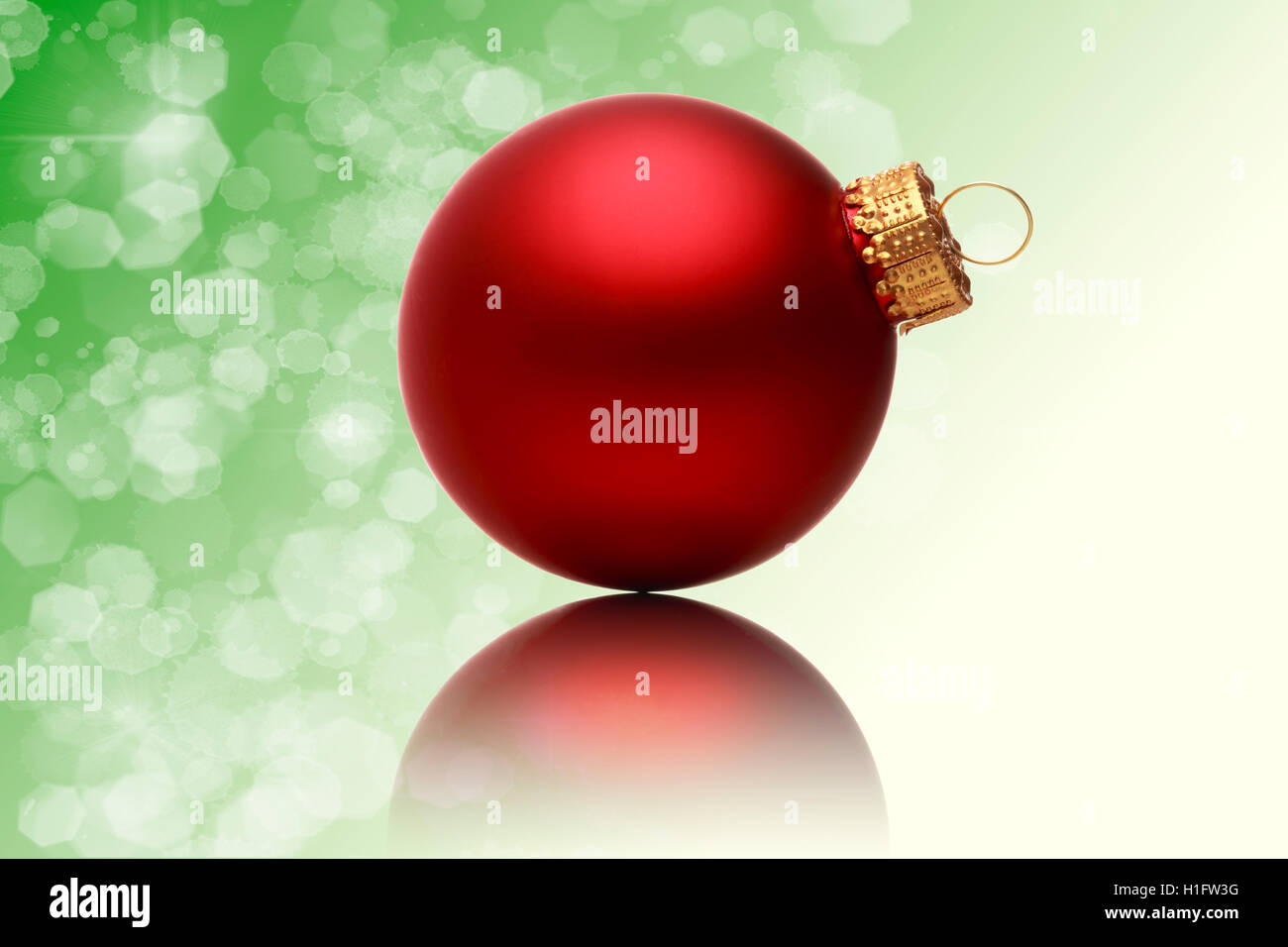 Close up di un rosso palla di Natale con sfocato sfondo verde Foto Stock