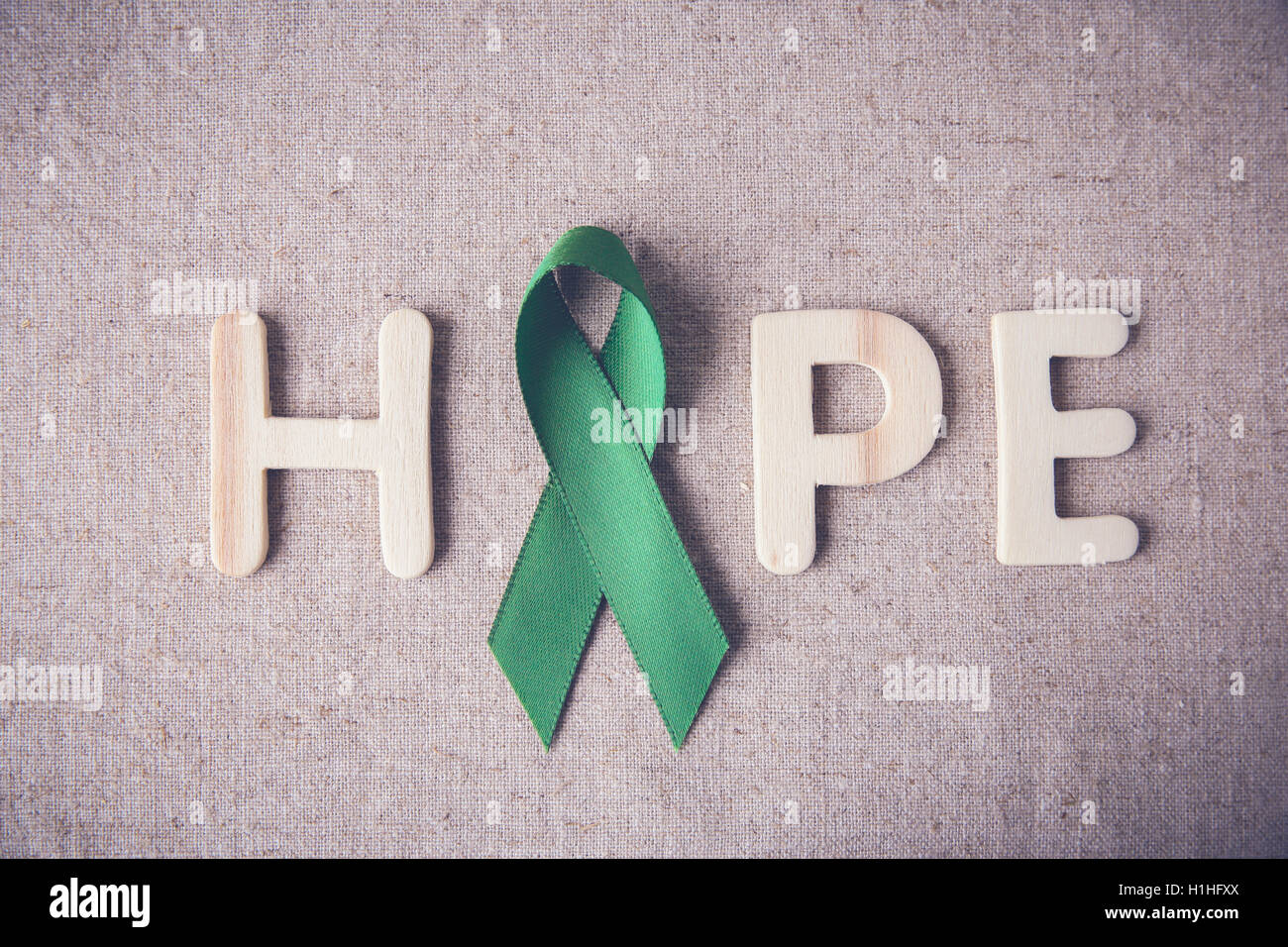 Nastro Verde con la speranza di parola in legno, cancro consapevolezza, fegato, cancro del rene consapevolezza Foto Stock