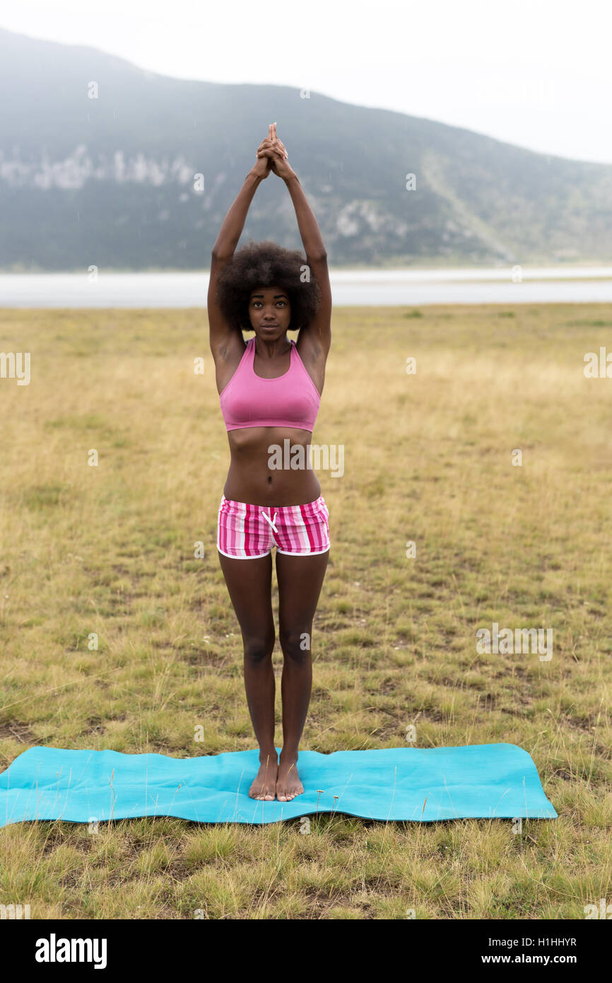 La donna a praticare yoga posizioni su erba in montagna Foto Stock