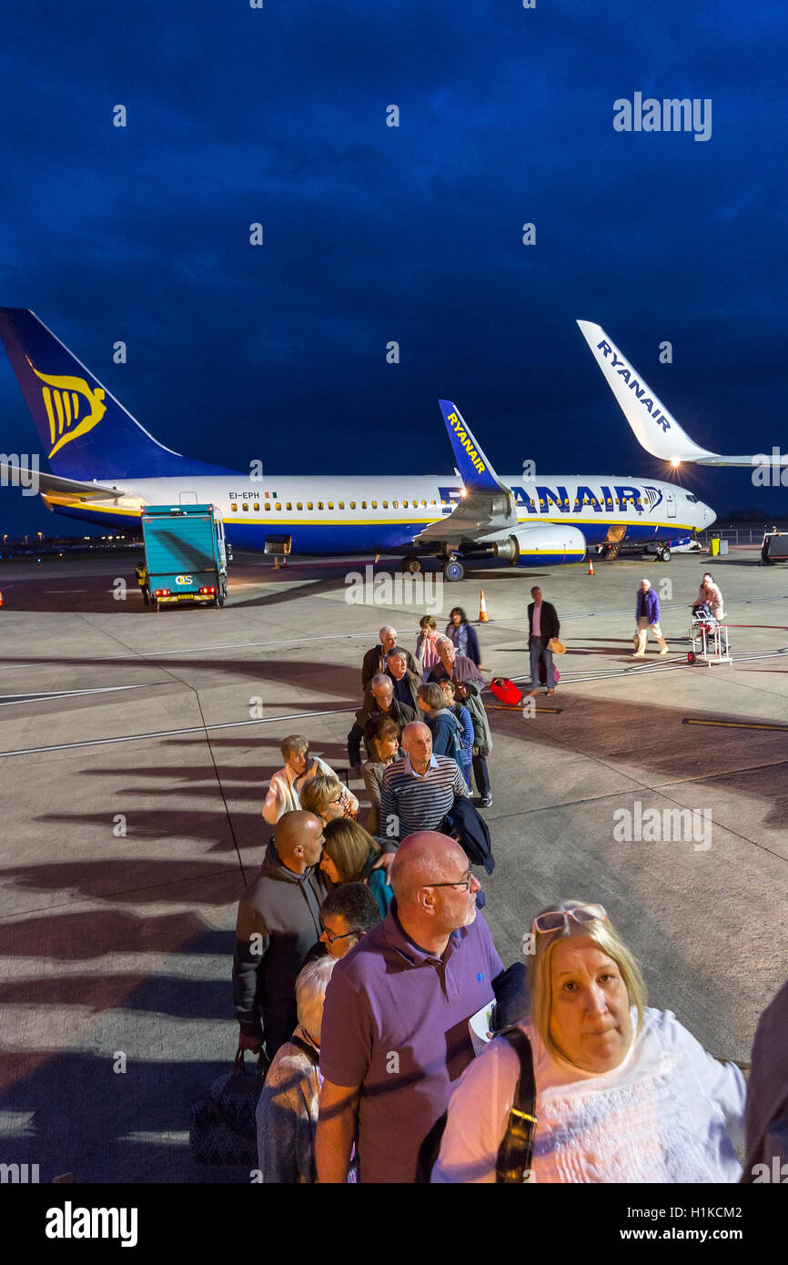 I passeggeri di salire a bordo di un volo Ryanair all'alba, l'aeroporto di Bristol, Inghilterra, Regno Unito Foto Stock