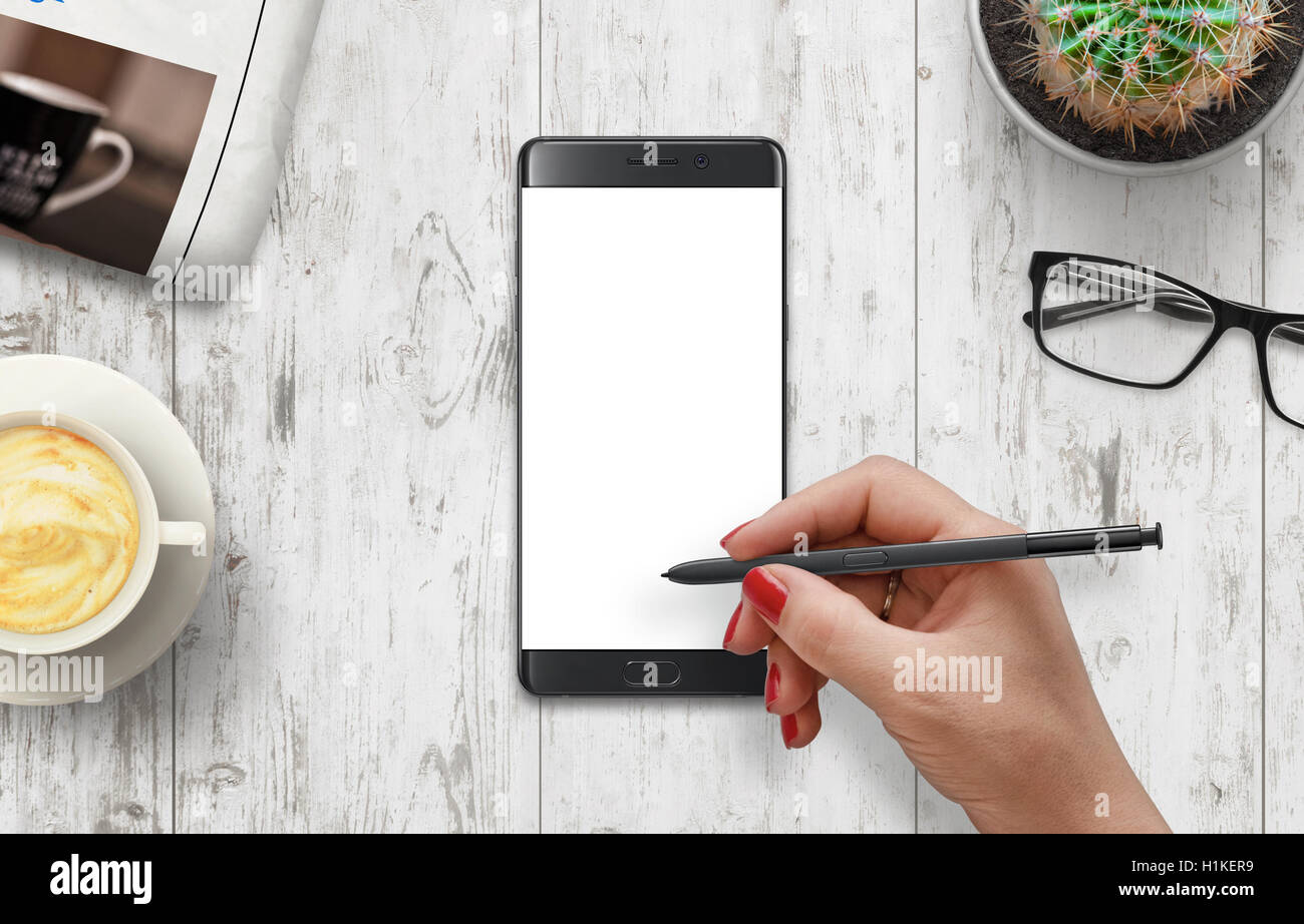 Ragazza di scrivere con la penna sul bianco isolato cellulare visualizzazione. Foto Stock