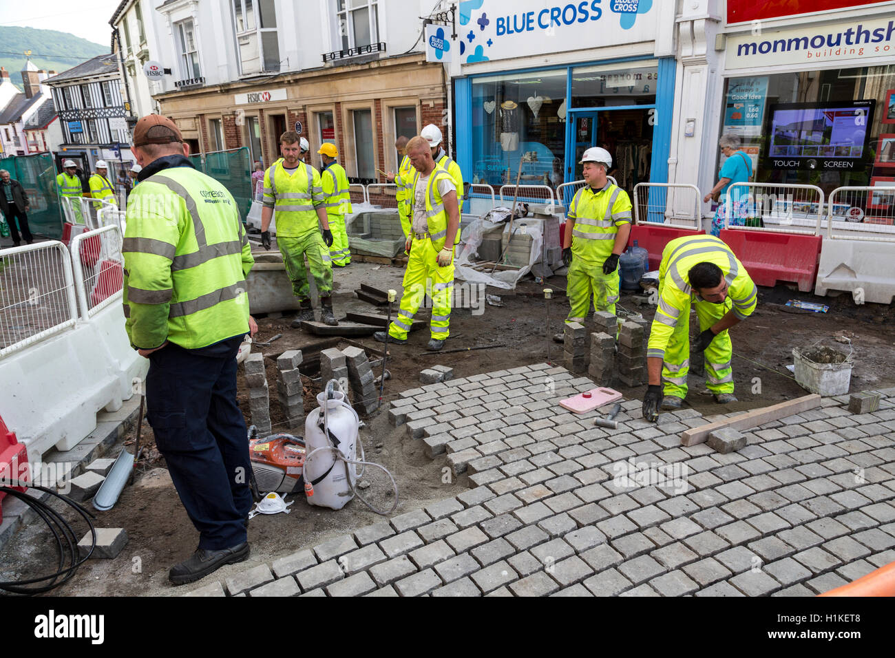 Operai posa strada pedonale di superficie nel centro di Abergavenny, Wales, Regno Unito Foto Stock