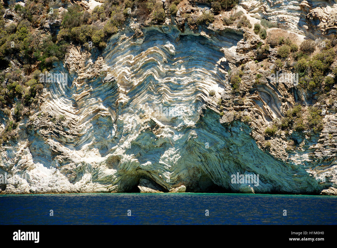 Exterme piegatura e le grotte di punta meridionale ISOLE IONIE Grecia greco edifici piuttosto yacht ormeggiati di ancoraggio ISOLE IONIE Grecia Foto Stock