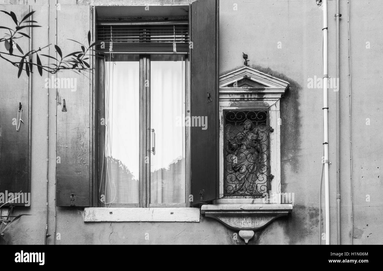 Un cattolico edicola votiva sul muro di una casa accanto al San Giacomo da l'Orio chiesa in Venezia, in bianco e nero. Foto Stock