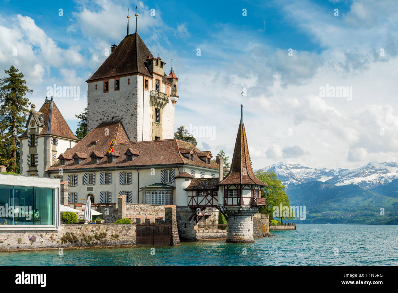 Bella torre del castello di Oberhofen nel lago di Thun con le montagne sullo sfondo della Svizzera nei pressi di Berna. Foto Stock