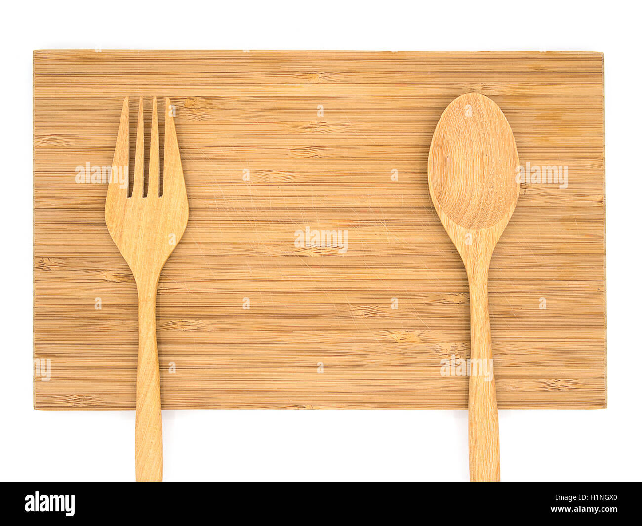 Vista dall'alto di un tagliere di legno con il cucchiaio di legno e la forcella con sfondo bianco Foto Stock