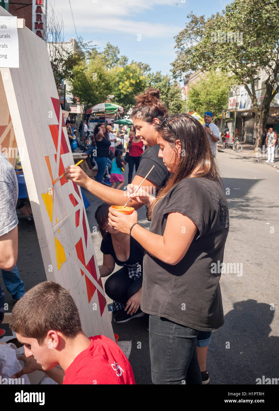 Studenti del college volontario di vernice punta murali di abbellire il Jackson Heights quartiere di Queens a New York Sabato, 17 settembre 2016. La Jackson Heights quartiere è la casa di un mosaico di etnie accanto indiani che includono pakistani, Tibetani, sud-est asiatico e da lungo tempo ebraica e residenti italiani. (© Richard B. Levine) Foto Stock