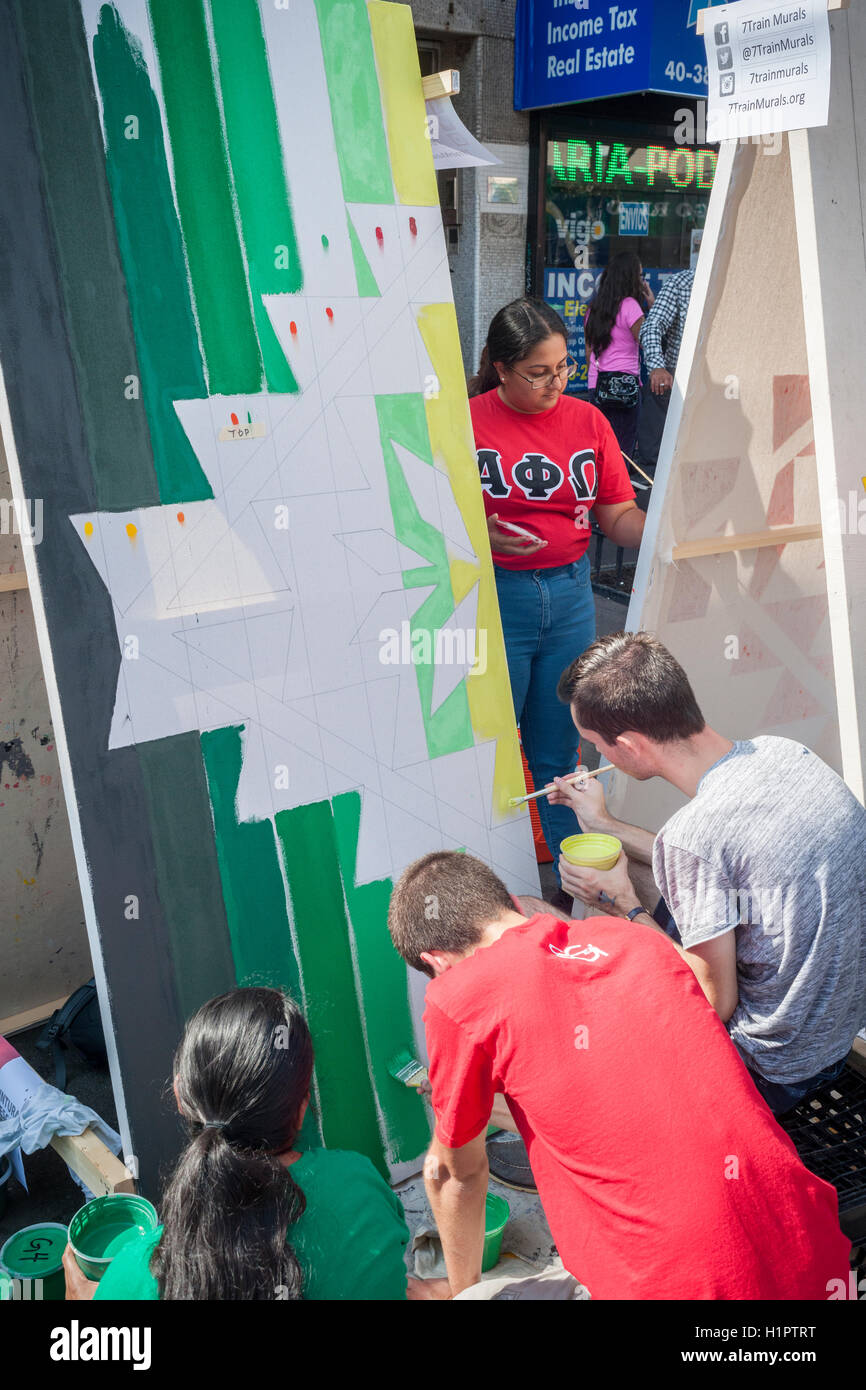 Studenti del college volontario di vernice punta murali di abbellire il Jackson Heights quartiere di Queens a New York Sabato, 17 settembre 2016. La Jackson Heights quartiere è la casa di un mosaico di etnie accanto indiani che includono pakistani, Tibetani, sud-est asiatico e da lungo tempo ebraica e residenti italiani. (© Richard B. Levine) Foto Stock