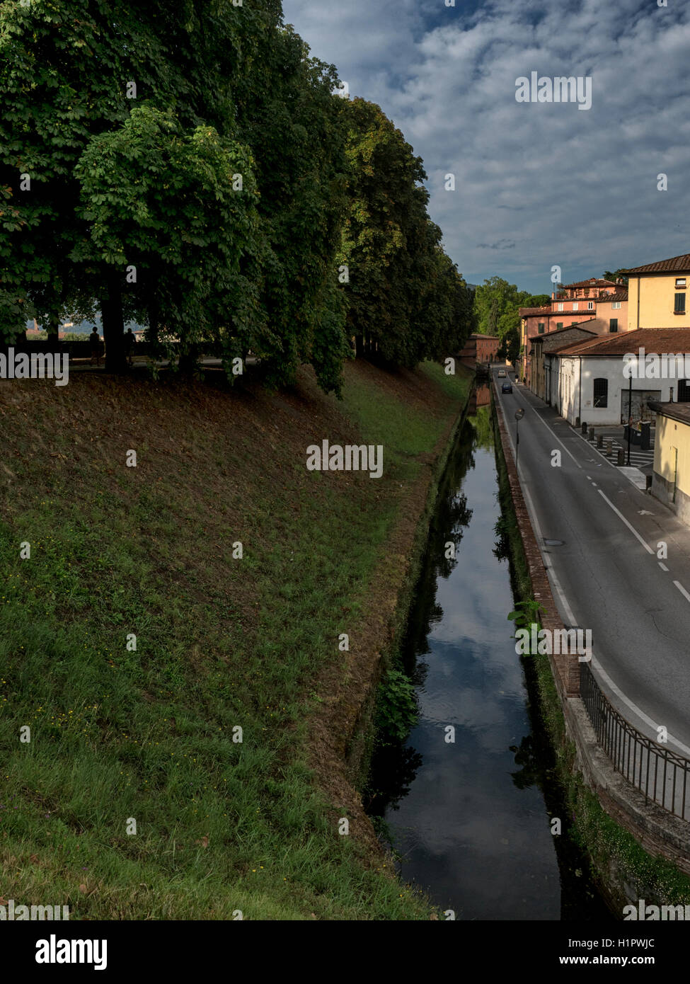 Le antiche mura e il vecchio fossato, ora un canal, a Lucca, Toscana, Italia Foto Stock