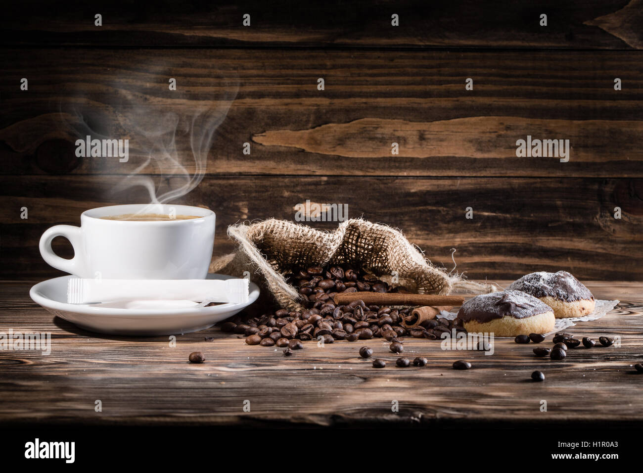 Tazza di caffè e caffè in grani sullo sfondo di legno. Foto Stock