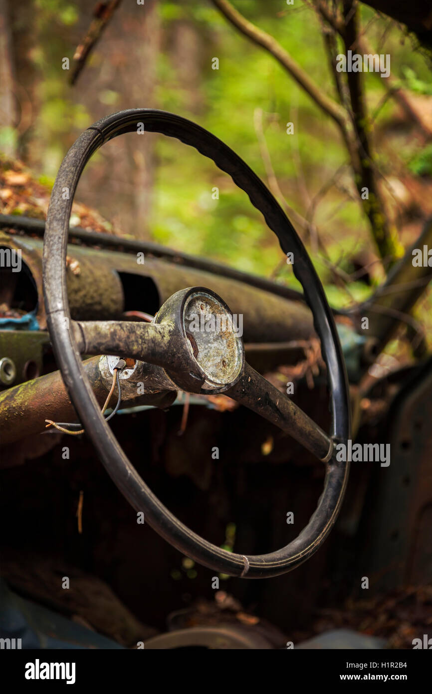 In prossimità del volante di guida di un abbandonato rusty vecchia auto. Foto Stock