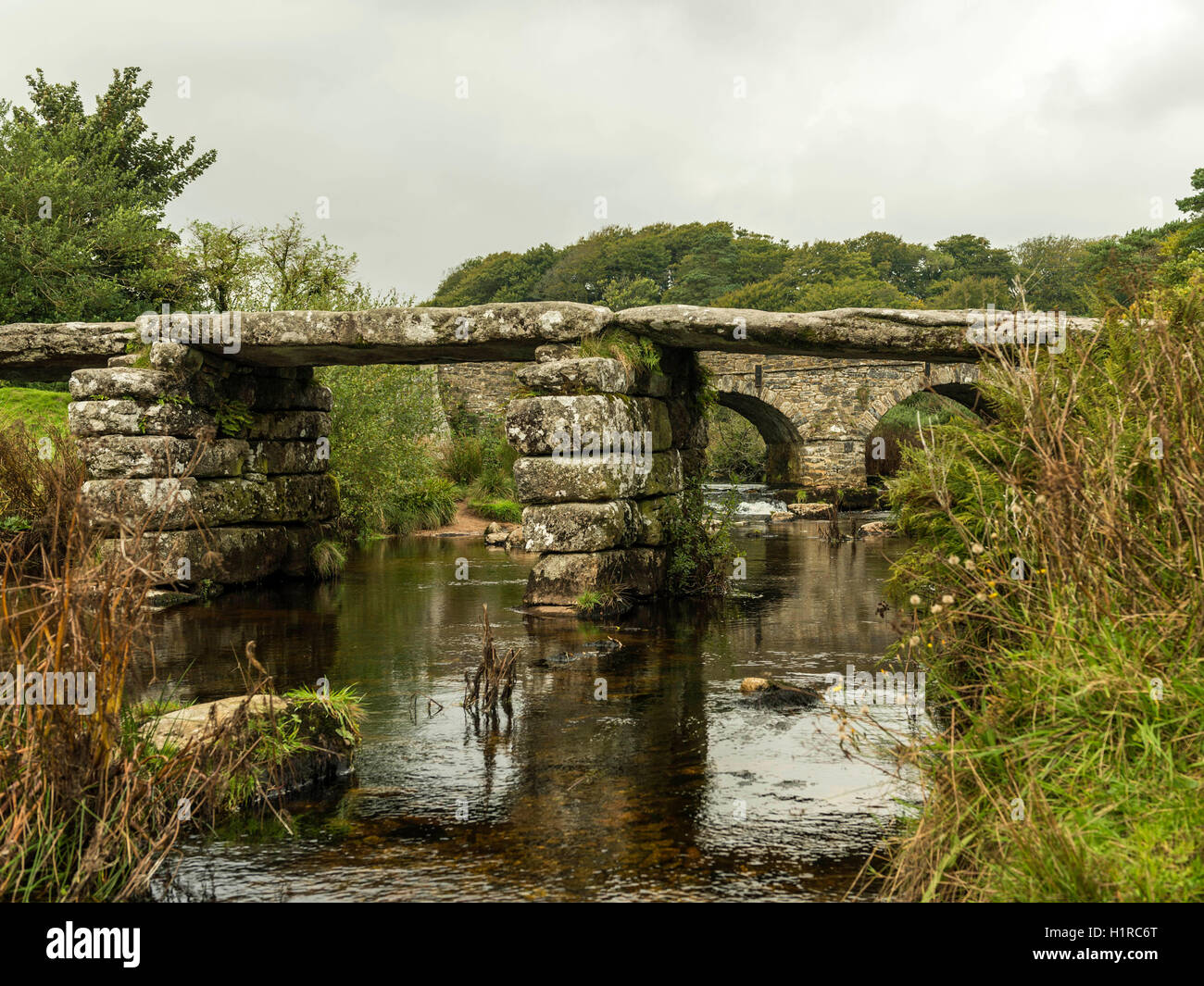 Bellissimo Dartmoor paesaggio con il ponte di pietra e a est del fiume Dart a Postbridge, Devon su un nuvoloso giorno. Foto Stock