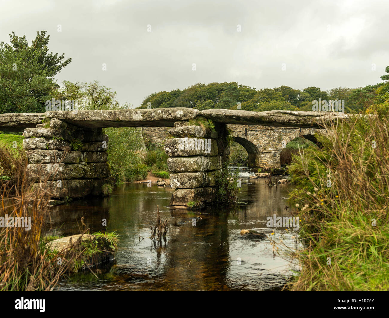 Bellissimo Dartmoor paesaggio con il ponte di pietra e a est del fiume Dart a Postbridge, Devon su un nuvoloso giorno. Foto Stock