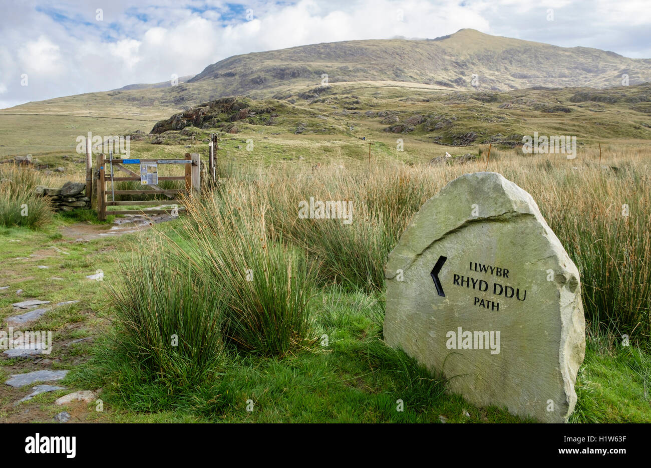 Cartello in pietra sul sentiero Rhyd Ddu fino al Monte Snowdon con vista a picco nella nuvola oltre nel Parco Nazionale di Snowdonia (Eryri). Rhyd Ddu Gwynedd Wales Uk Foto Stock