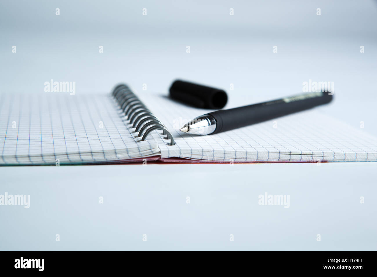 La penna sulla carta a scacchi notebook Foto Stock