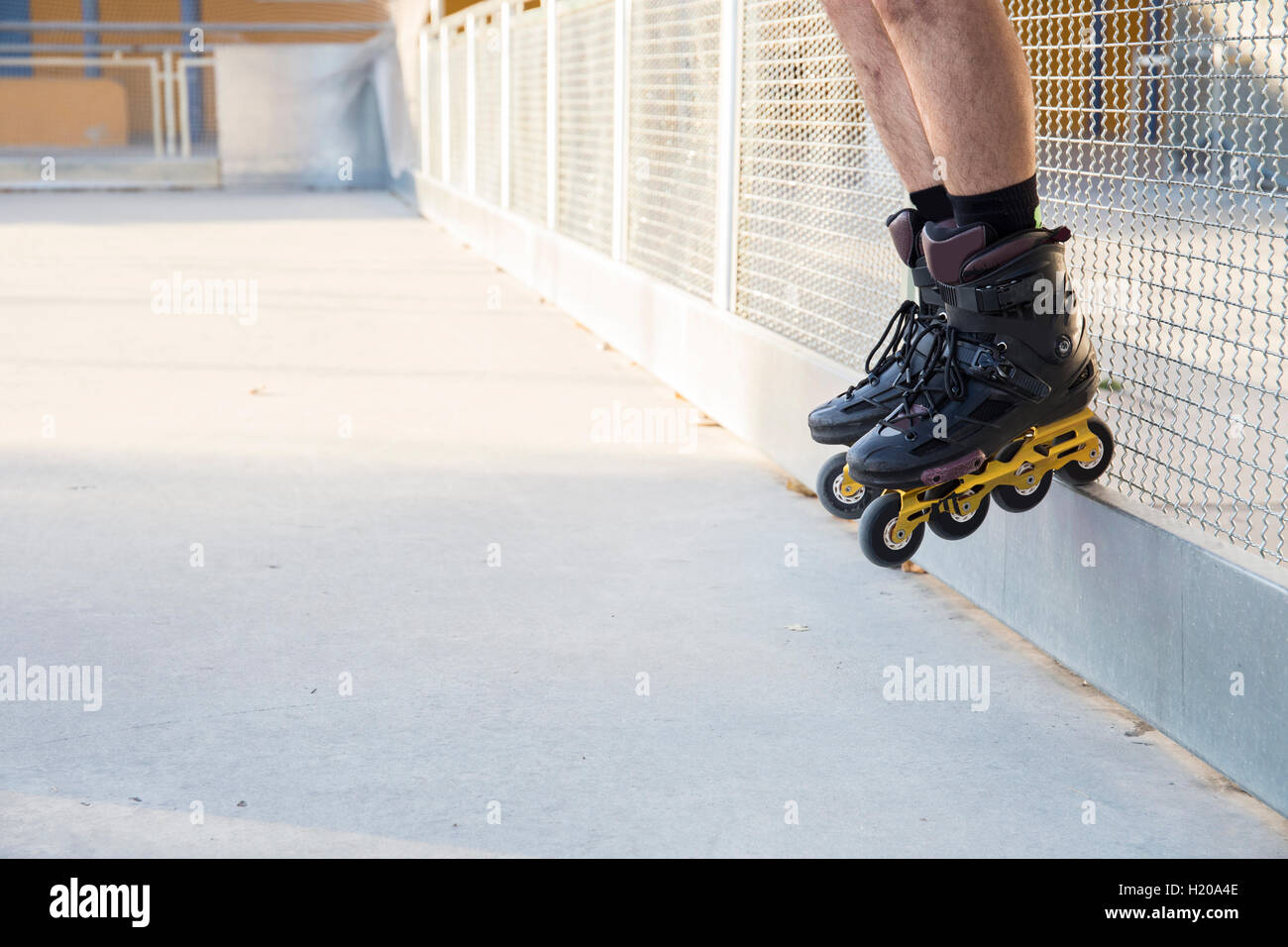 Le gambe di un uomo con pattini su una ringhiera Foto Stock