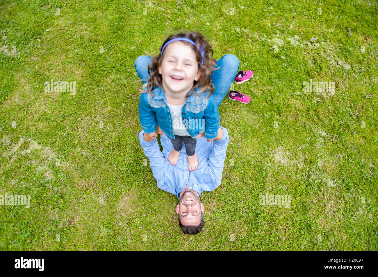 Padre e figlia giocando sul prato in posizione di parcheggio Foto Stock