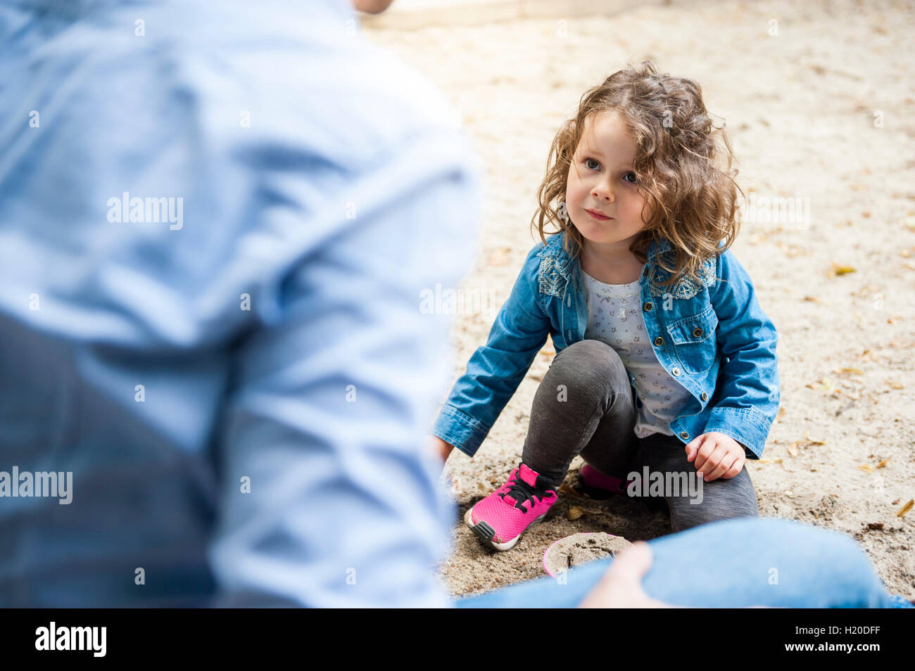 Padre giocando con la figlia in sandbox Foto Stock