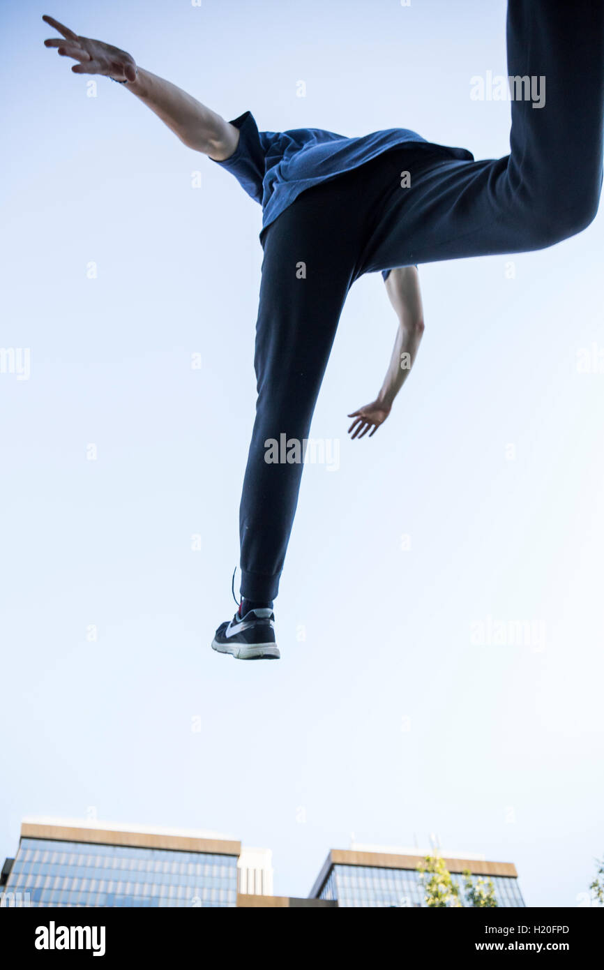 Spagna, Madrid, uomo jumping in città durante una sessione di parkour, basso angolo di visione Foto Stock