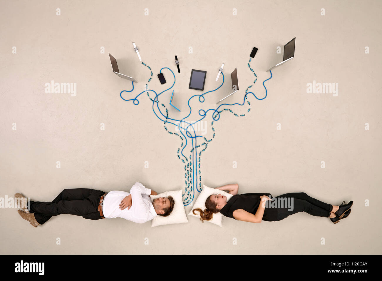 Due colleghi di lavoro dormendo collegato ai dispositivi mobili Foto Stock