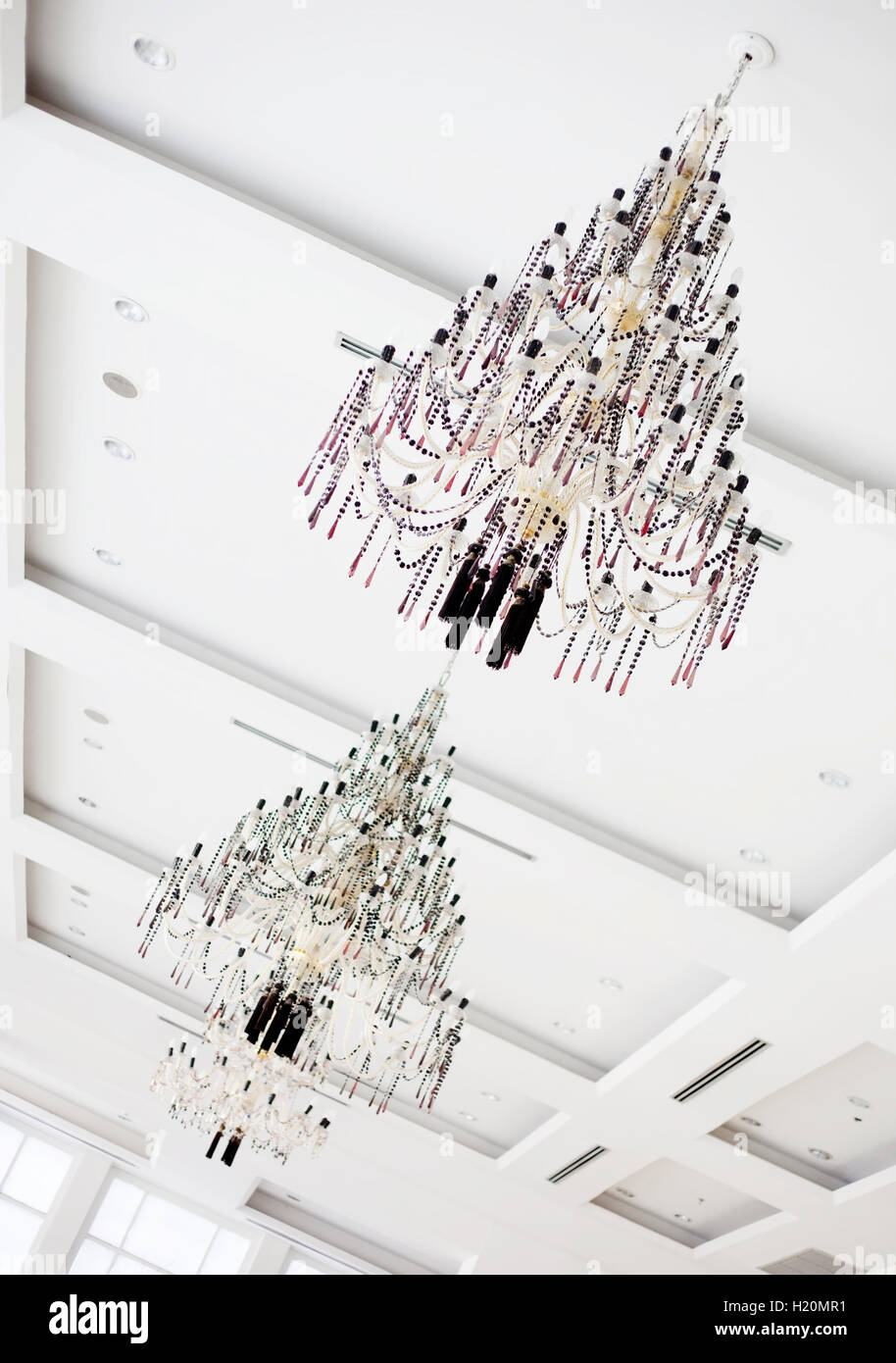 Due candelieri di cristallo appesa al soffitto bianco Foto Stock