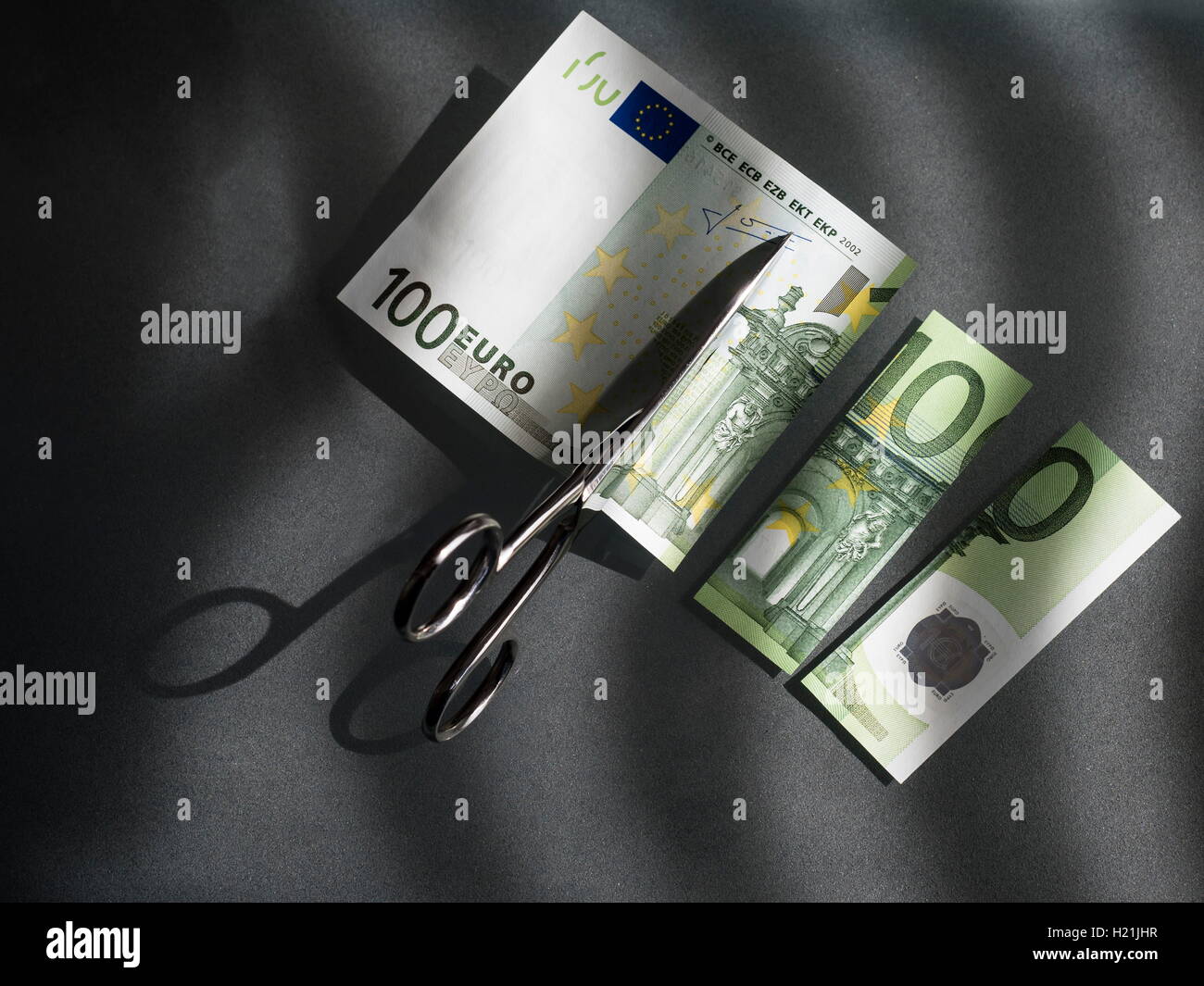 100 euro e un paio di forbici, immagine simbolica, costi Foto Stock