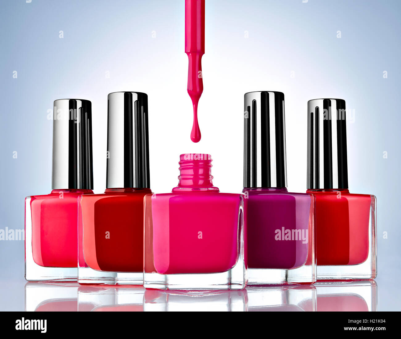 Close up di smalto per unghie su sfondo blu, rosso, drop Foto Stock