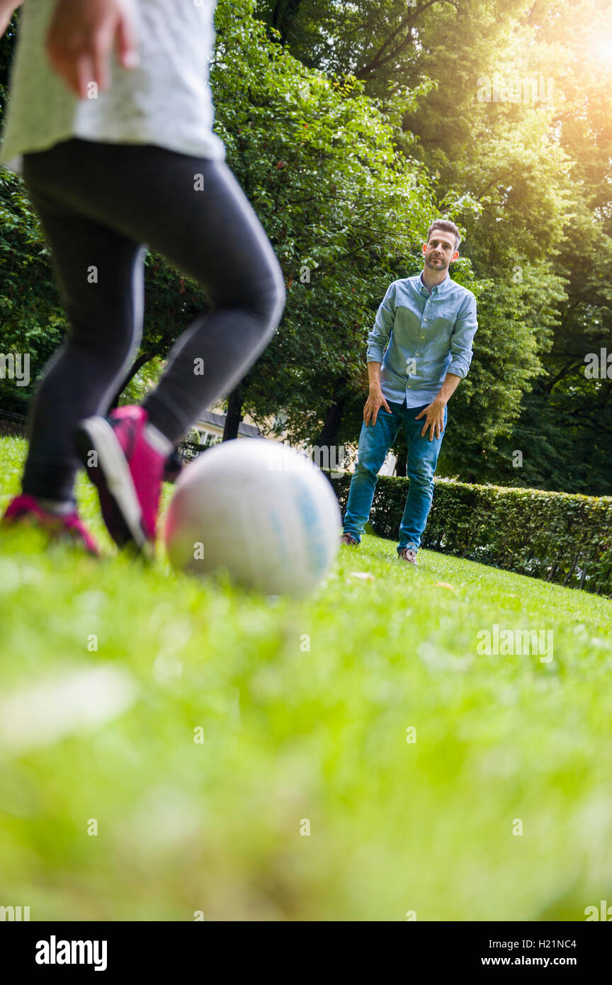 Padre e figlia a giocare a calcio in posizione di parcheggio Foto Stock