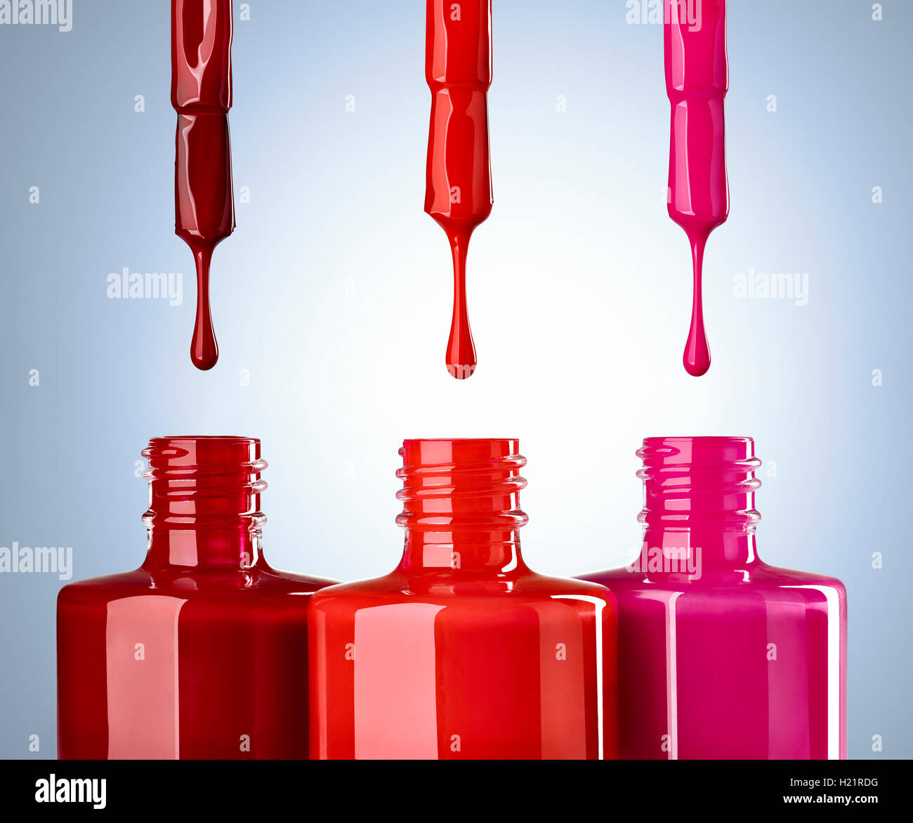 Close up di smalto per unghie su sfondo blu, rosso, drop Foto Stock