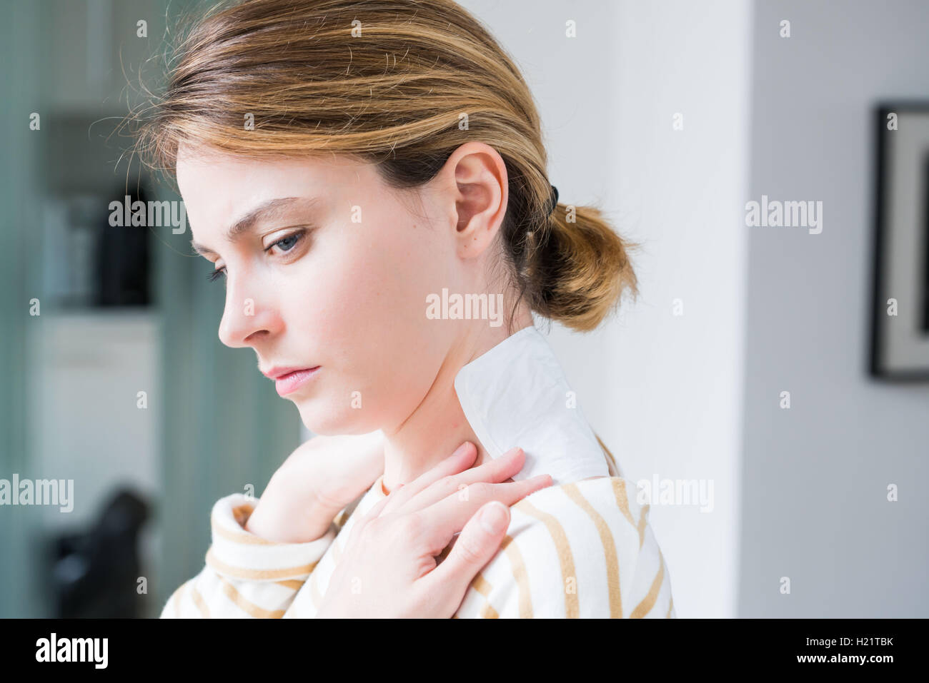 Donna applicando calore patch per il mal di schiena. Foto Stock